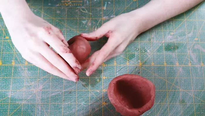 Score the lips of both bowls and stick them together, blending the seams.