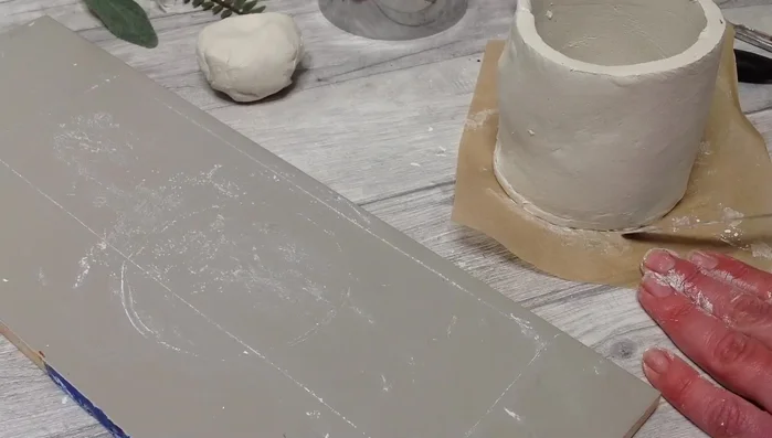 Use the score and slip method to attach the base and clay slab.