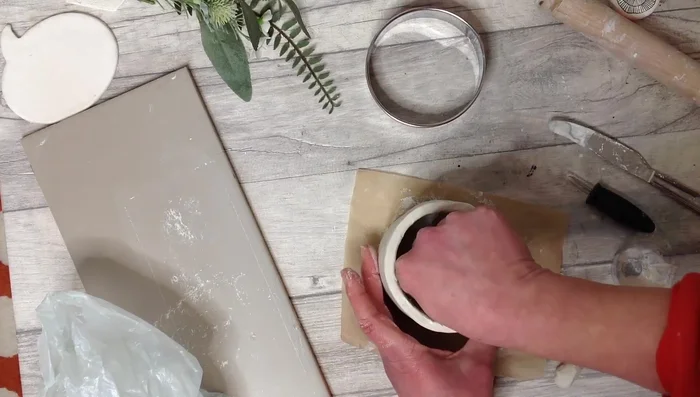 Add a coil of clay and slip to the inside, smoothing with a damp sponge.