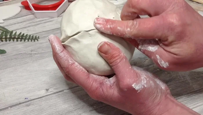 Roll the clay into a ball, then shape it into your desired vase shape.