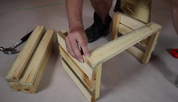 Flip the crate and attach the side slats, three per side. Again, start with one nail per piece to allow for adjustment and squaring.