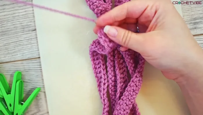 Lay the 5 strands beside each other, secure them with a tapestry needle and thread, and pin them to your cutting board.