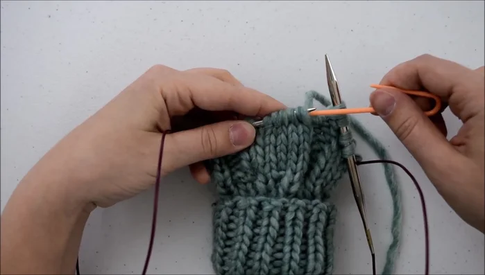 Slip the first three stitches onto your cable needle and hold it behind your work.