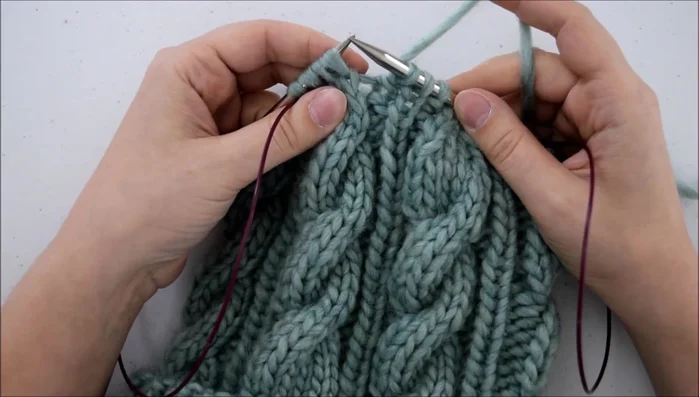 Bring your left needle back through the front of both stitches and knit them together.