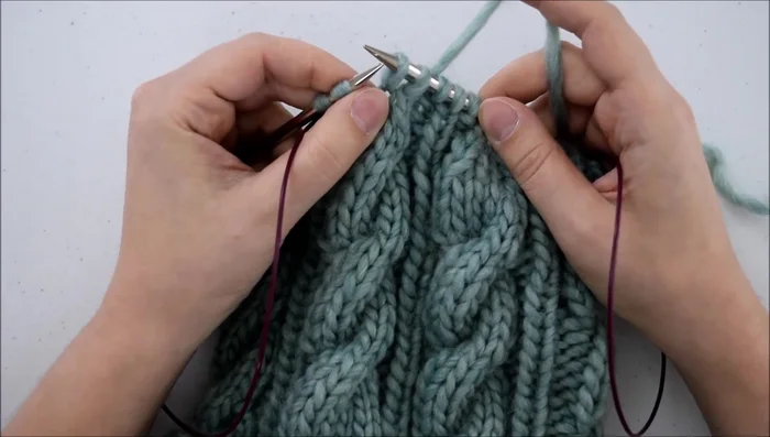 Bring your left needle back through the front of both stitches and knit them together.