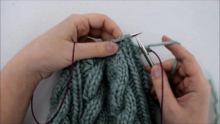 Pass the two slipped stitches over the stitch you just knit.