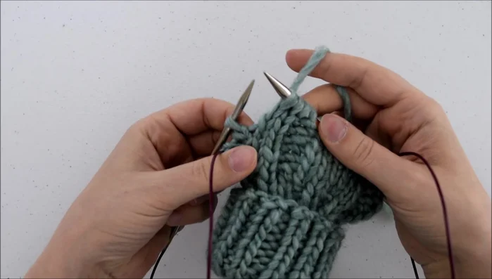 Knit through the front of that loop.