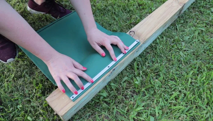 Using the metal bracket as a guide, mark and create holes in the new fabric where the screws will go. An awl is recommended, but a screwdriver and hammer can be used as a substitute.
