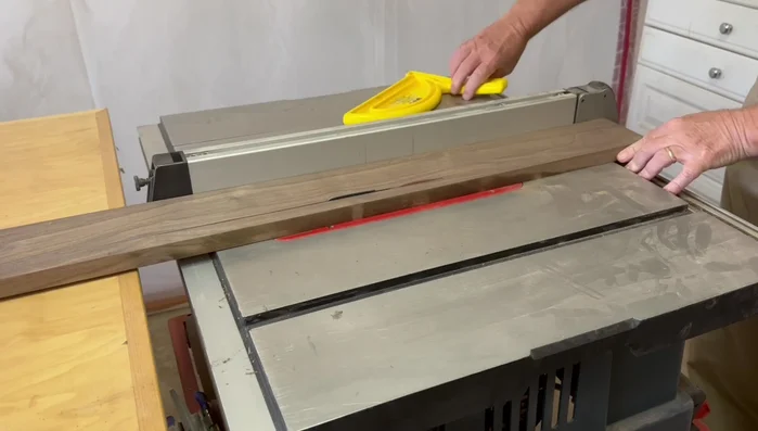 Cut 45-degree angles on the ends of the side pieces using the table saw and a crosscut slot, ensuring accuracy with a stop block.