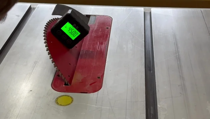 Cut 45-degree angles on the ends of the side pieces using the table saw and a crosscut slot, ensuring accuracy with a stop block.