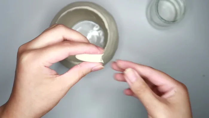 Create the facial features using small amounts of clay. Roll out clay for the nose and eyes, then make a small line for the mouth.