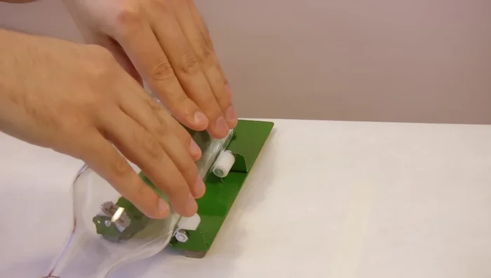 Place the bottle on the cutter's center and turn it until you hear a crunching sound.