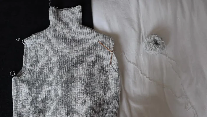 Pick up stitches around the armhole for sleeves. (Note: The video mentions unraveling and redoing this step due to forgotten shaping, highlighting the importance of planning.)