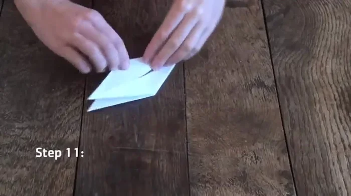 Fold both edges to the center crease, ensuring the triangle is at the top. Repeat on the other side.