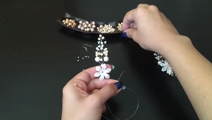 Add a small bead and secure the flower bead in the center using two additional pearls.