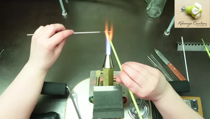 Build the bottom half (shank) of the knob, applying glass to the bottom of the insert, ensuring it doesn't touch the mandrel. Use a shaping tool to smooth and create a nicely rounded shank.