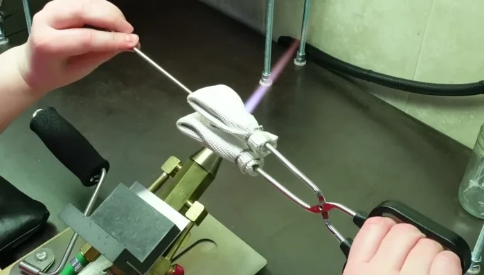 Remove the knob from the mandrel using padded tongs or mashers, and place in a kiln to anneal. If removal is difficult, anneal the whole assembly and remove afterward.