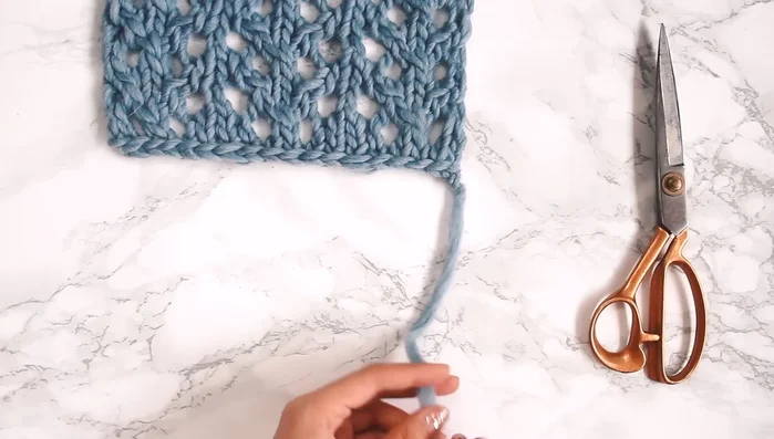 Attach fringe (10-inch lengths of yarn, 3 strands per section). Attach to the wrong side of the scarf using a smaller needle. Ensure knots are consistent on both sides of the scarf.