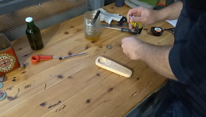Apply wood glue to the area where the coin will be placed. Secure the coin and attach it with the screw.