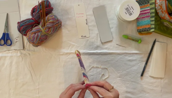 Sew the knitted tube to the cardboard using a mattress stitch.
