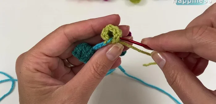 Shape the popcorn beads into round spheres by using a darning needle to weave the yarn under the Vs of the double crochets, gently shaping and securing the ends.