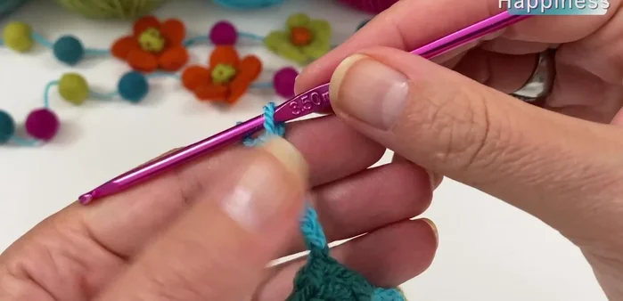 Create the flower components: chain 13 (after a popcorn), work a double crochet in the third chain from the hook, chain 10. Repeat the popcorn stitch process.