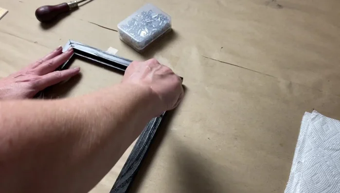 Add hanging hardware: Attach D-rings or hooks to the back of the frame.