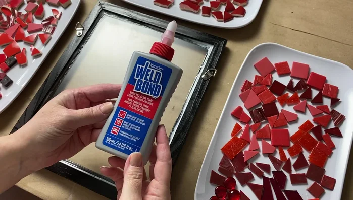 Tile the mosaic: Arrange the tesserae creatively, avoiding placing identical pieces next to each other. Work in sections if needed and wipe off excess adhesive.