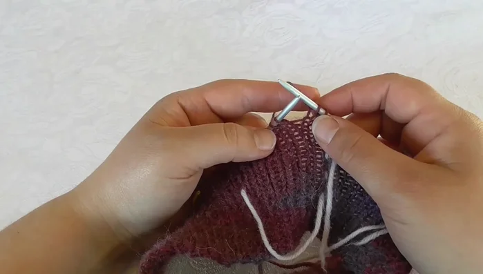 Slip one stitch, move yarn to the back, slip stitch back onto the left needle, turn. Purl back across sleeve and back stitches. Then, purl the last two stitches and continue to the next section.