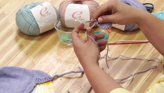 Knit across the newly cast-on stitches and the stitches of the second ear flap.