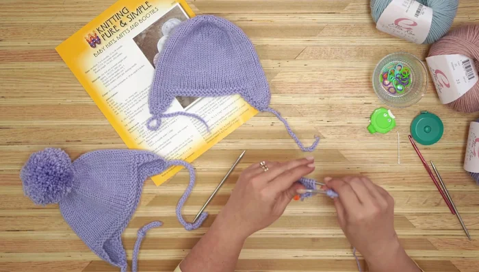 Knit across the newly cast-on stitches and the stitches of the second ear flap.