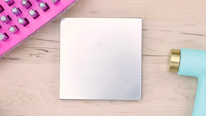 Place a 3.25-inch circle blank on your stamping block. Adhere a small circle stamp guide to the top, centering it using stamp tape.