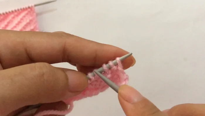 **Row 4:** Slip the first edge stitch purlwise, then repeat the pattern: purl three, knit one, purl one (until you reach the last stitch). Purl the last edge stitch.