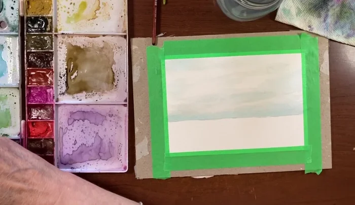 Once the sky is mostly dry, deepen the horizon line with a mixture of Prussian blue (or a similar dark blue). Keep it subtle and avoid harsh lines.