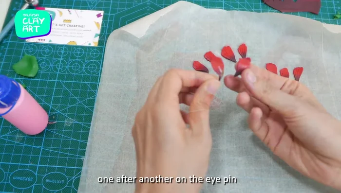 Glue petals around the eye pin, creating a hibiscus flower.