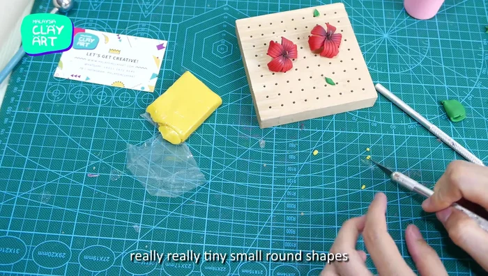 Add small yellow clay balls to the eye pin for added detail.