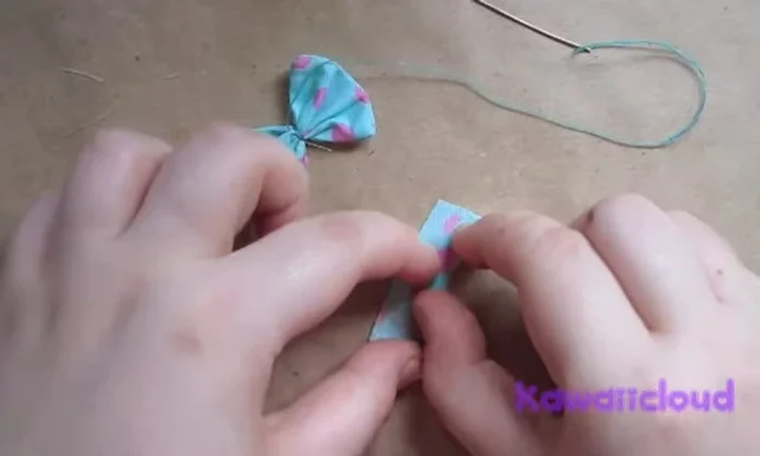 Make the second bow piece: cut another rectangular piece of fabric. Repeat steps 2-4 to create a second loop.