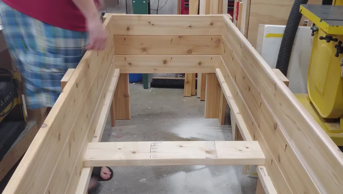 Install the bottom slats, starting with the middle one, using 3-inch screws and spacers.