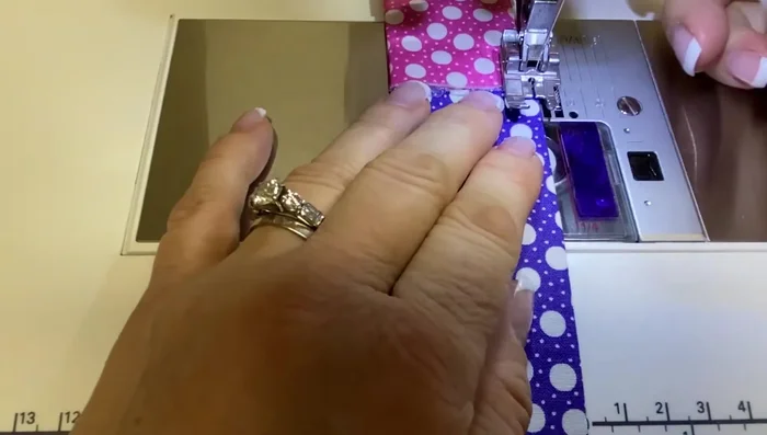 Attach Pockets to Front: Stitch the top edge of each pocket to the front piece, one inch apart, using the marked lines as a guide.