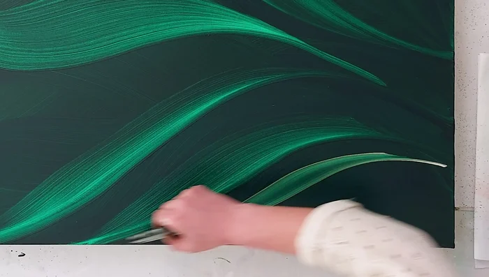 Introduce iridescent colors (iridescent gold) while the canvas is still wet to allow for blending and flow.