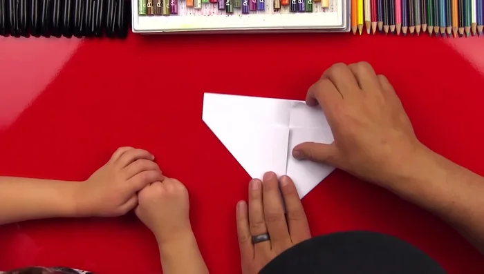 Fold the top layer down to create a smaller triangle on each side.