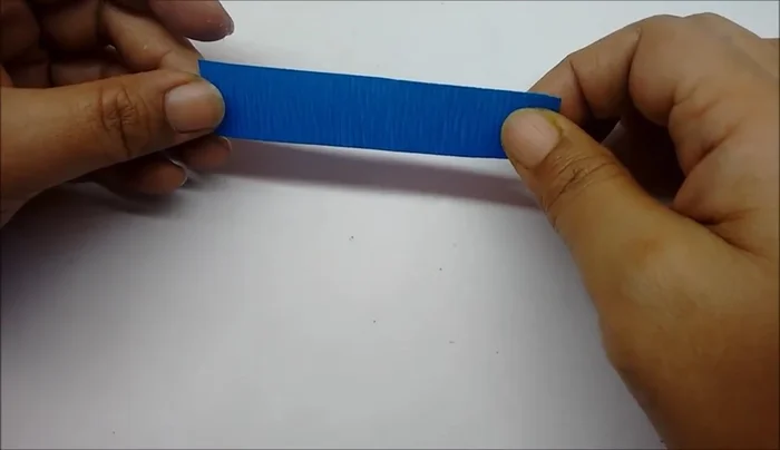 Prepare a glue strip (8cm long, 1.5cm wide) from blue paper. Attach the stamens to the strip.