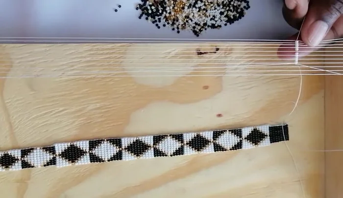 Lock the beads in place and continue. The first step is challenging; ensure no beads share a space.