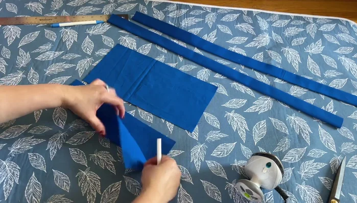 Prepare the pocket: Fold the pocket fabric in half, mark an inch from the side, and sew.