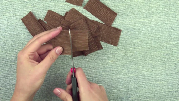 Prepare small pieces of crepe paper and cut out petal shapes. Stretch and press the paper to form petals.