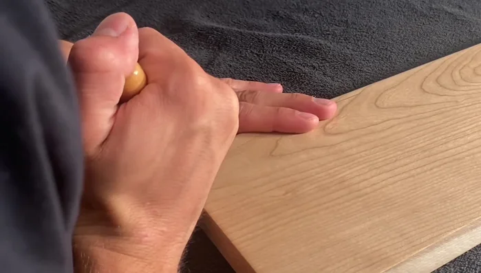 Use a chisel to clean the wood between carved lines and cleared areas.