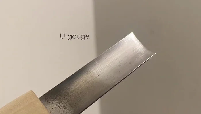 Use a chisel to clean the wood between carved lines and cleared areas.