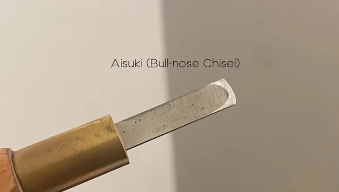 Use a chisel to clean the wood between carved lines and cleared areas.