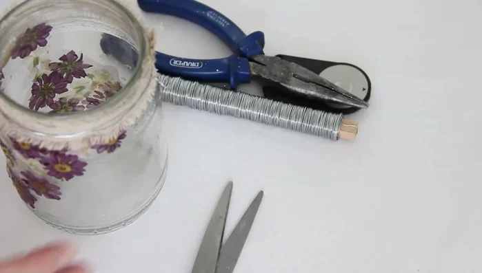 Create a handle and a heart hanger using floral wire. Twist the wire together to strengthen it, and attach securely to the jar.