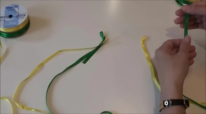 Create initial knots and loops: Tie a knot in one ribbon of each pair (your inside color), and create a loop in the other (your outside color). Leave a few inches of tail on each.